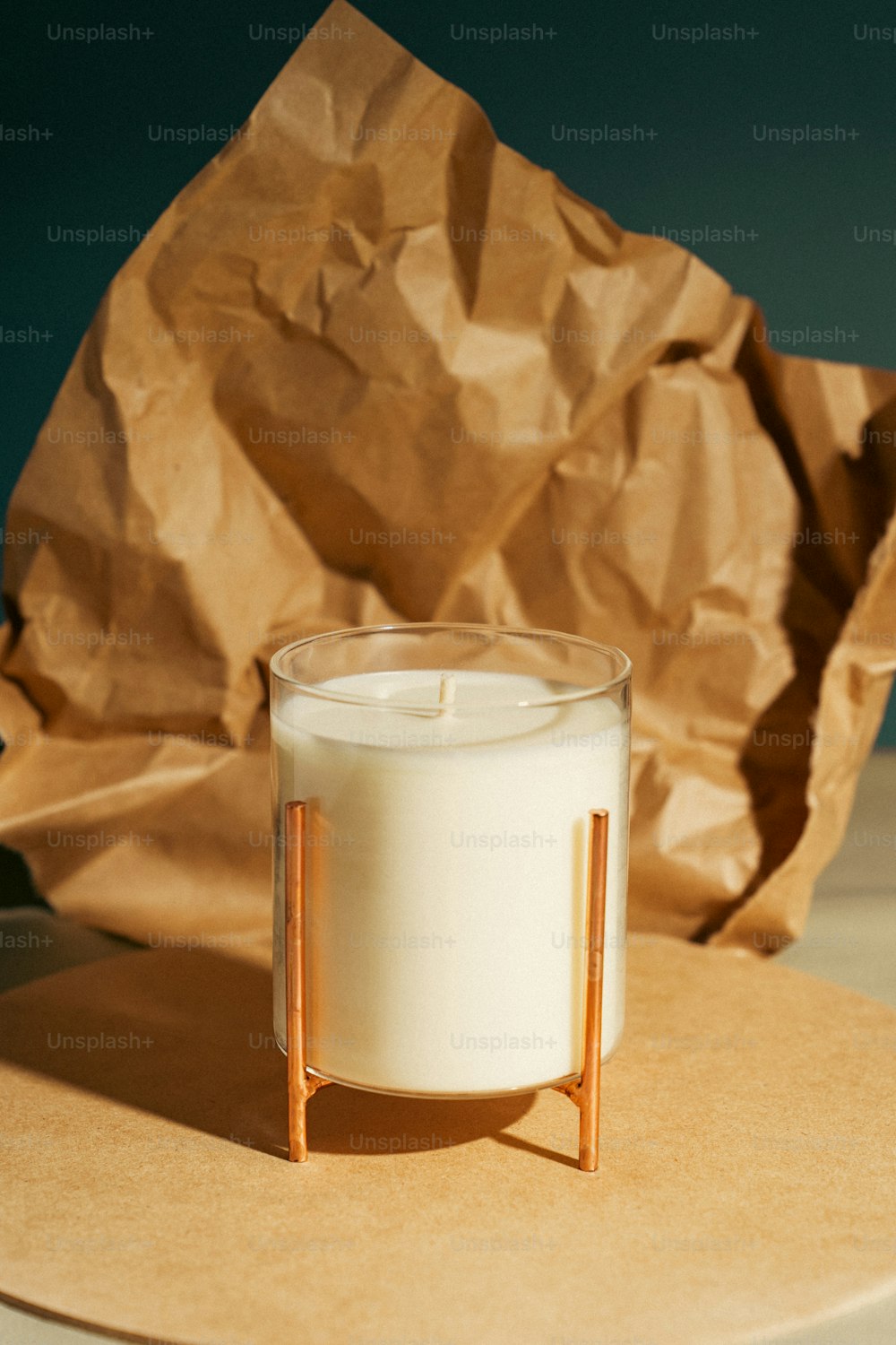 Una vela sentada encima de una mesa junto a una bolsa de papel marrón