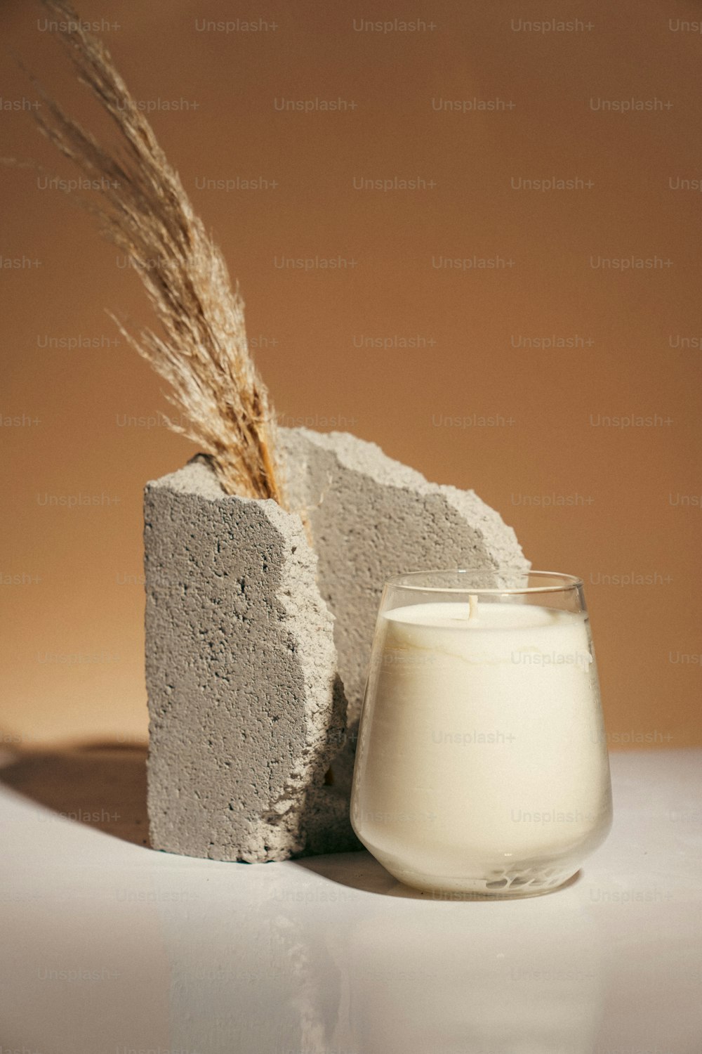a glass of milk next to a block of cement