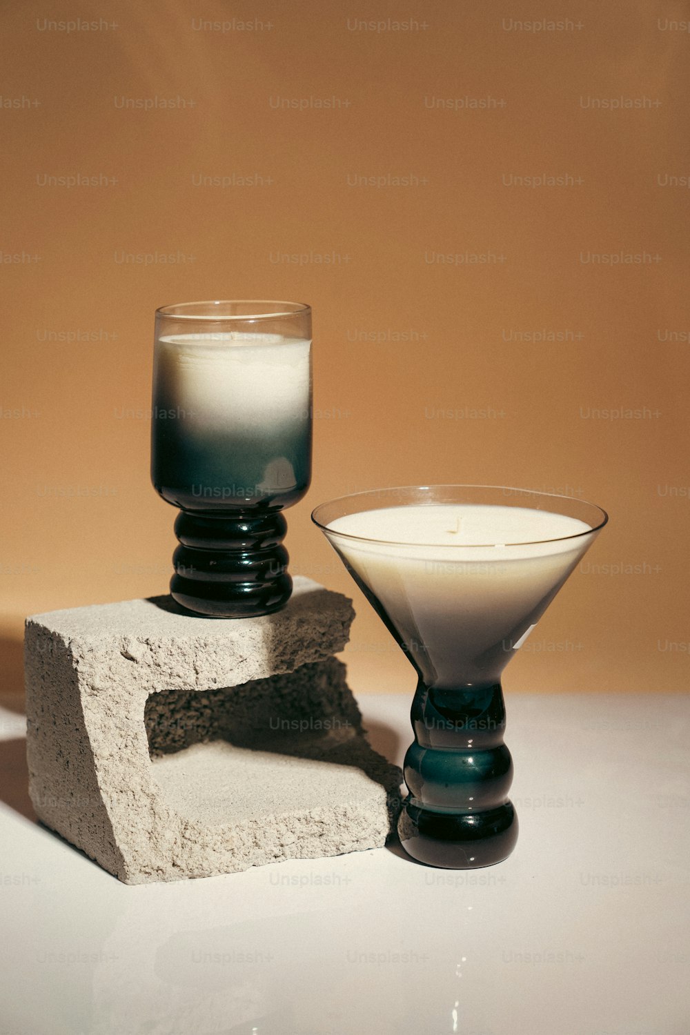 a glass of milk sitting next to a cement block
