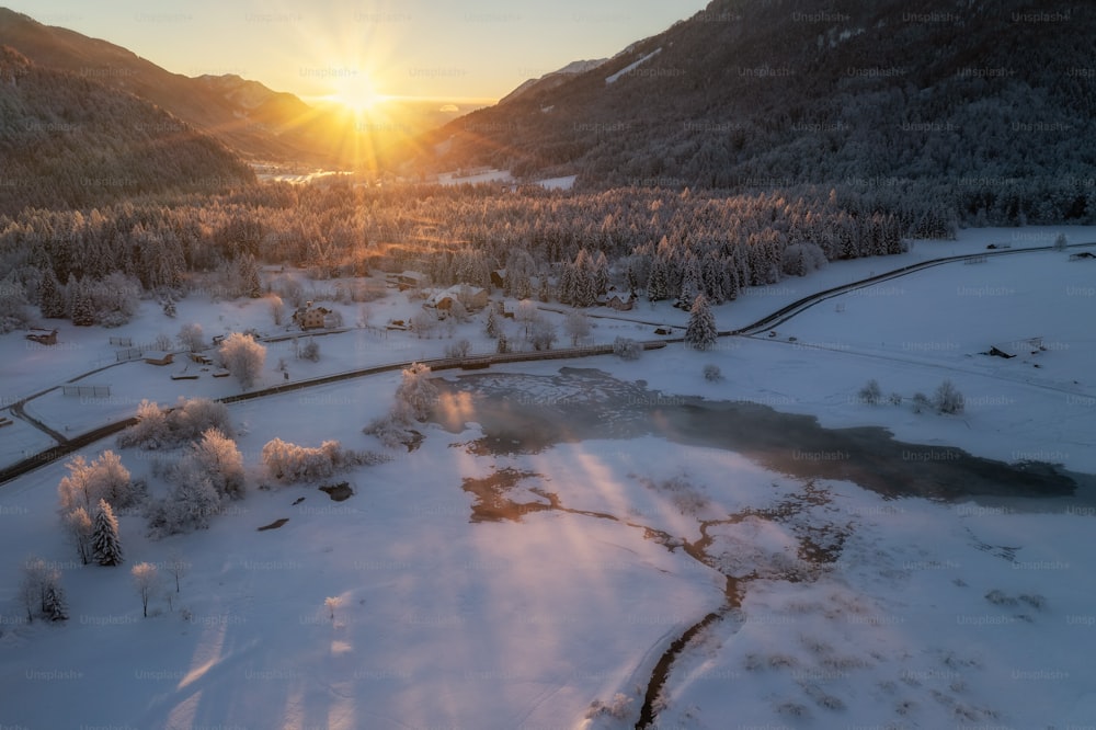 the sun is setting over a snowy valley