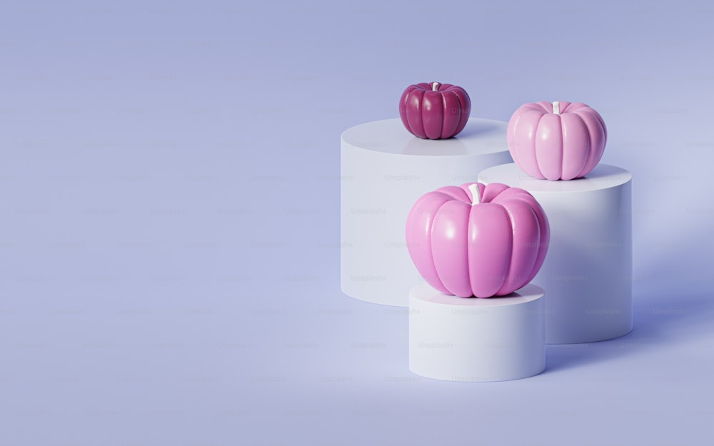 Drei rosafarbene Vasen, die auf einem weißen Sockel sitzen