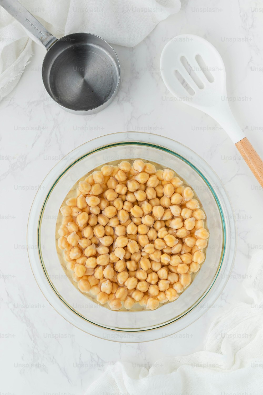 a bowl of chickpeas on a white table