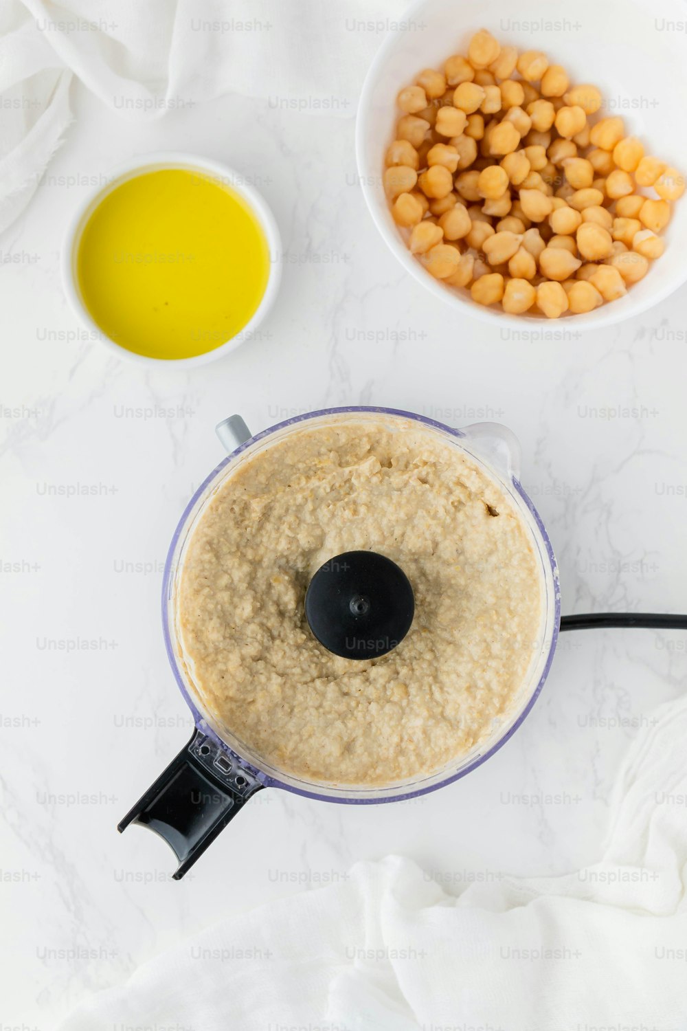 a food processor filled with food next to two bowls of food