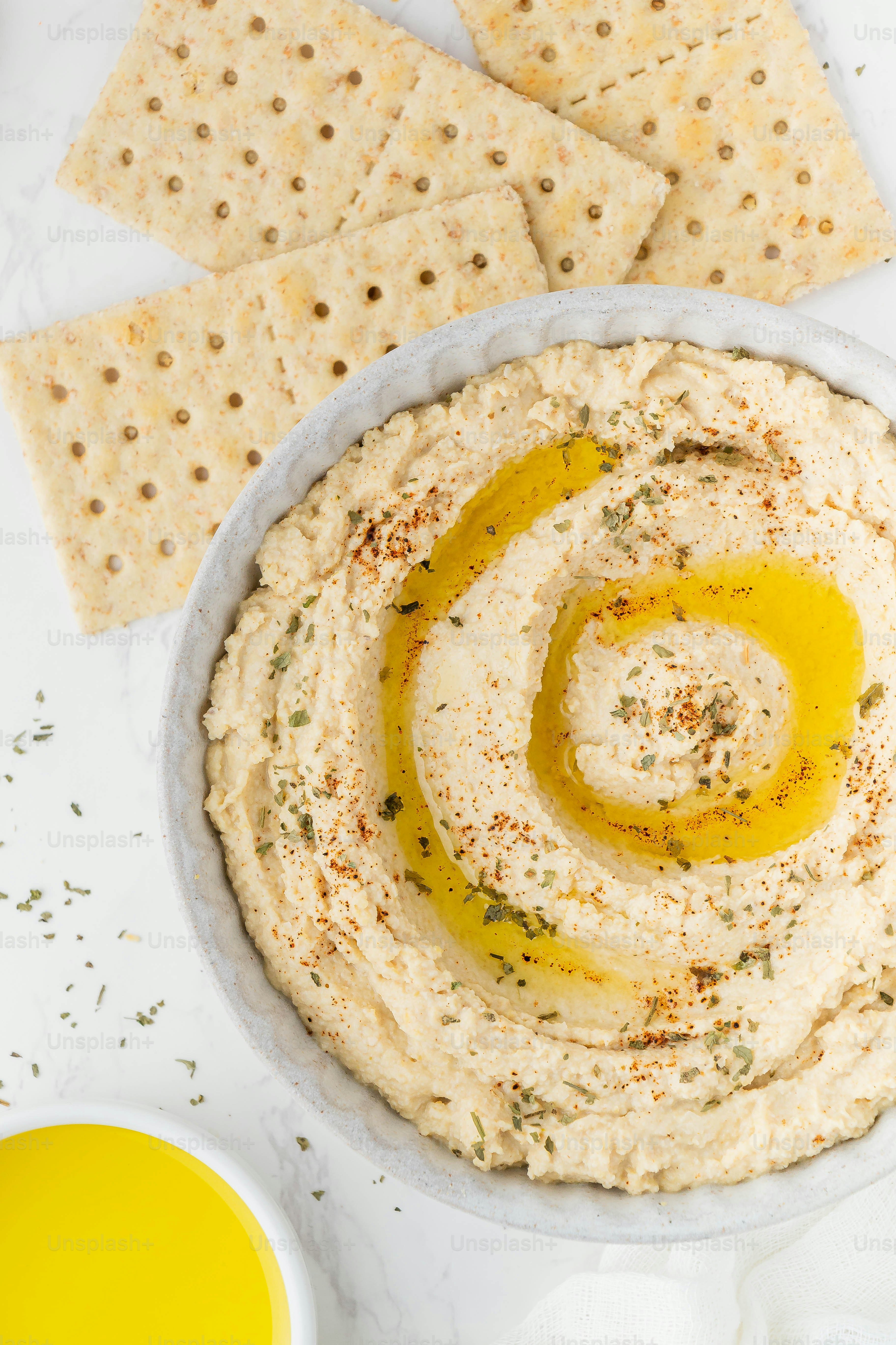 a bowl of hummus and crackers on a table