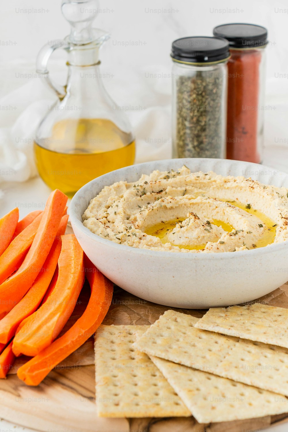 a bowl of hummus and crackers on a plate