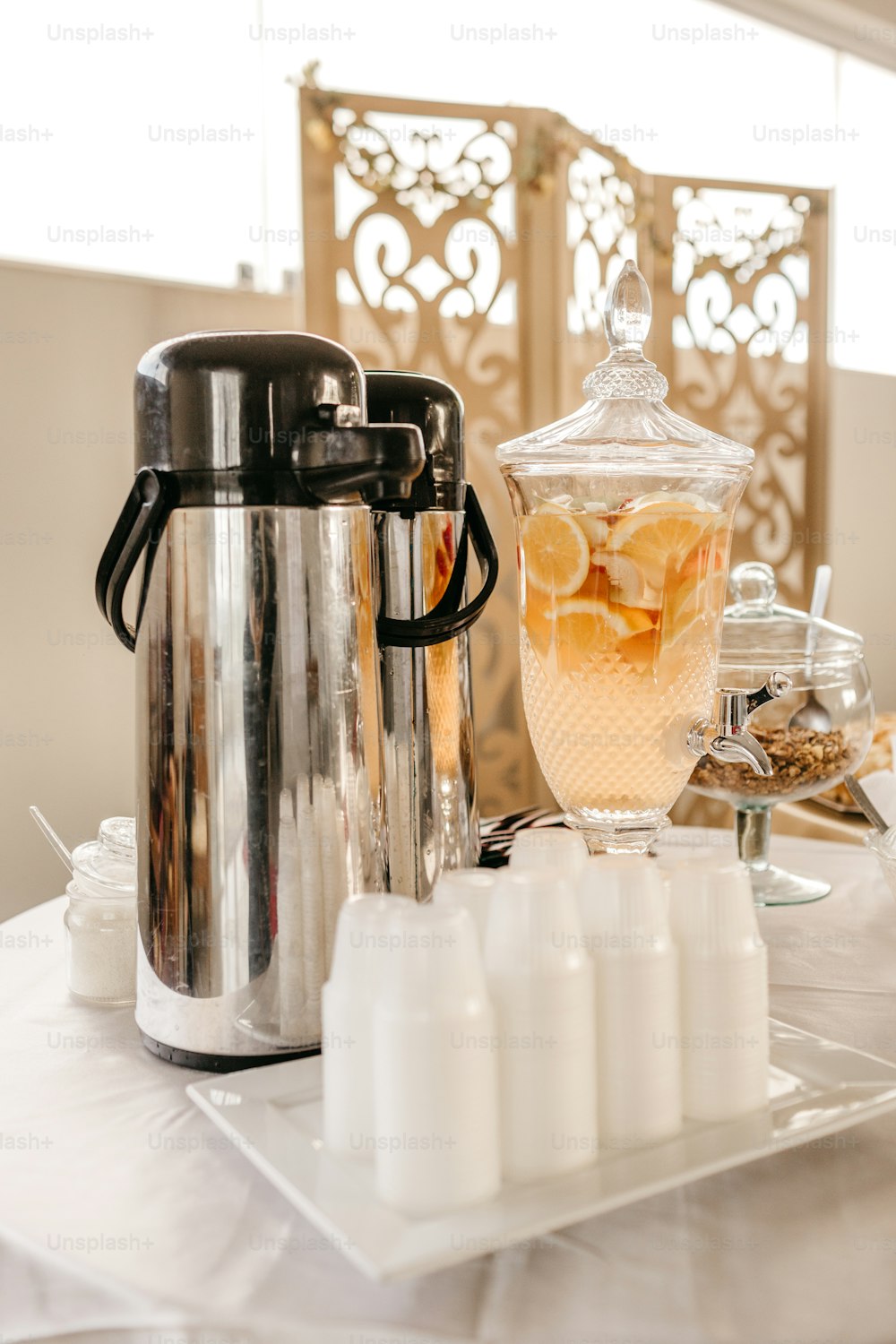 a table topped with a pitcher of liquid next to a container of liquid