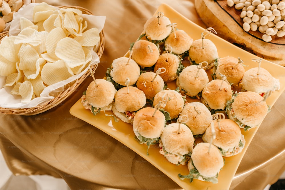 a table topped with plates of food and a basket of chips