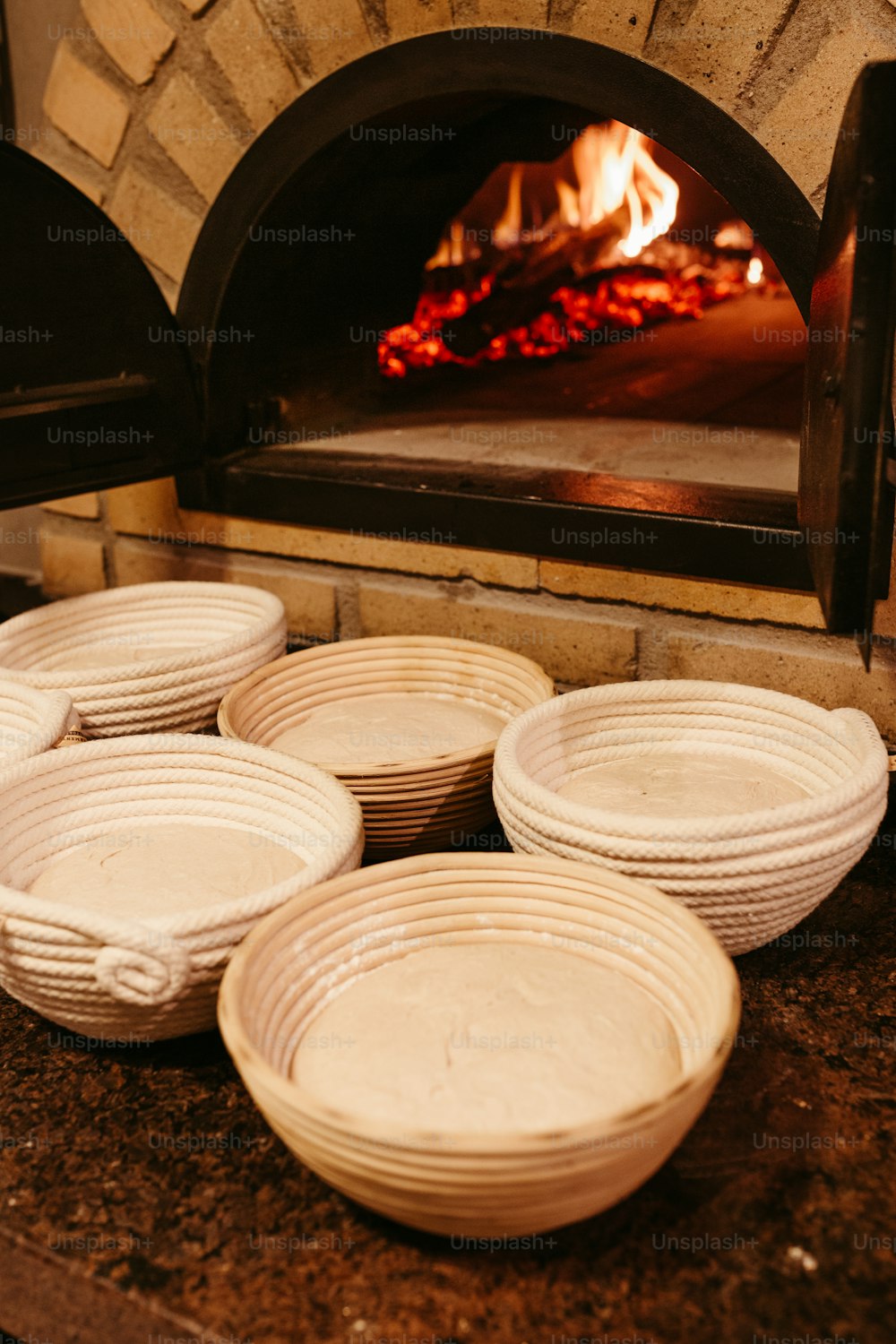 a bunch of bowls sitting in front of a brick oven