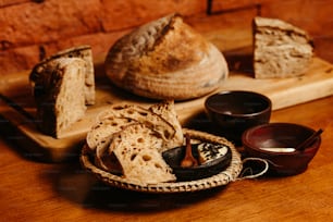 a wooden table topped with bread and bowls