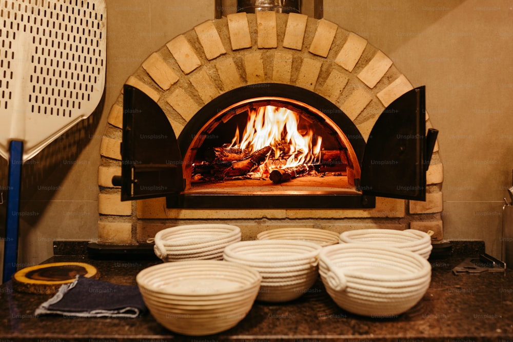 a bunch of white bowls sitting in front of a brick oven