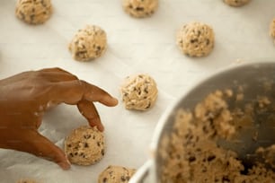 una mano che raggiunge un biscotto su una teglia da forno