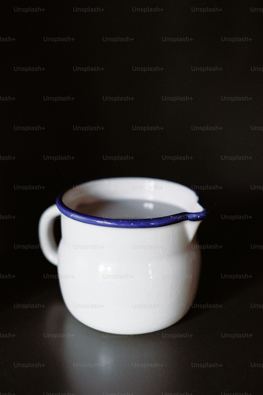 검은색 표면에 파란색 테두리가 있는 흰��색 그릇