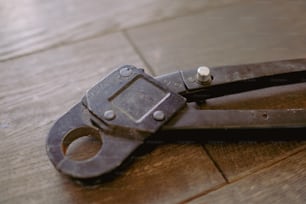 um close up de uma tesoura em um chão de madeira