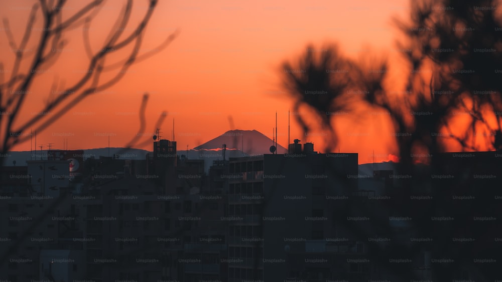 Die Sonne geht über einer Stadt mit hohen Gebäuden unter