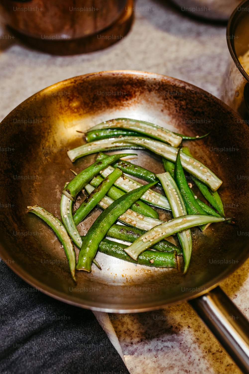 a pan filled with green beans on top of a table