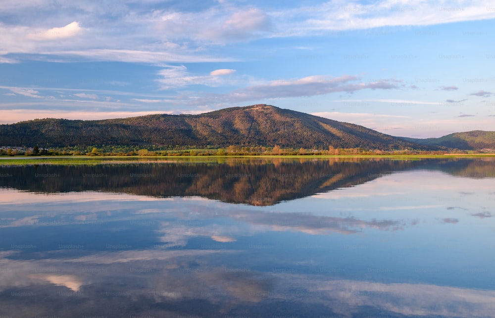 a large body of water with a mountain in the background