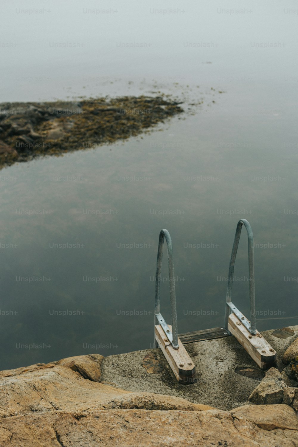 a pair of metal railings sitting next to a body of water