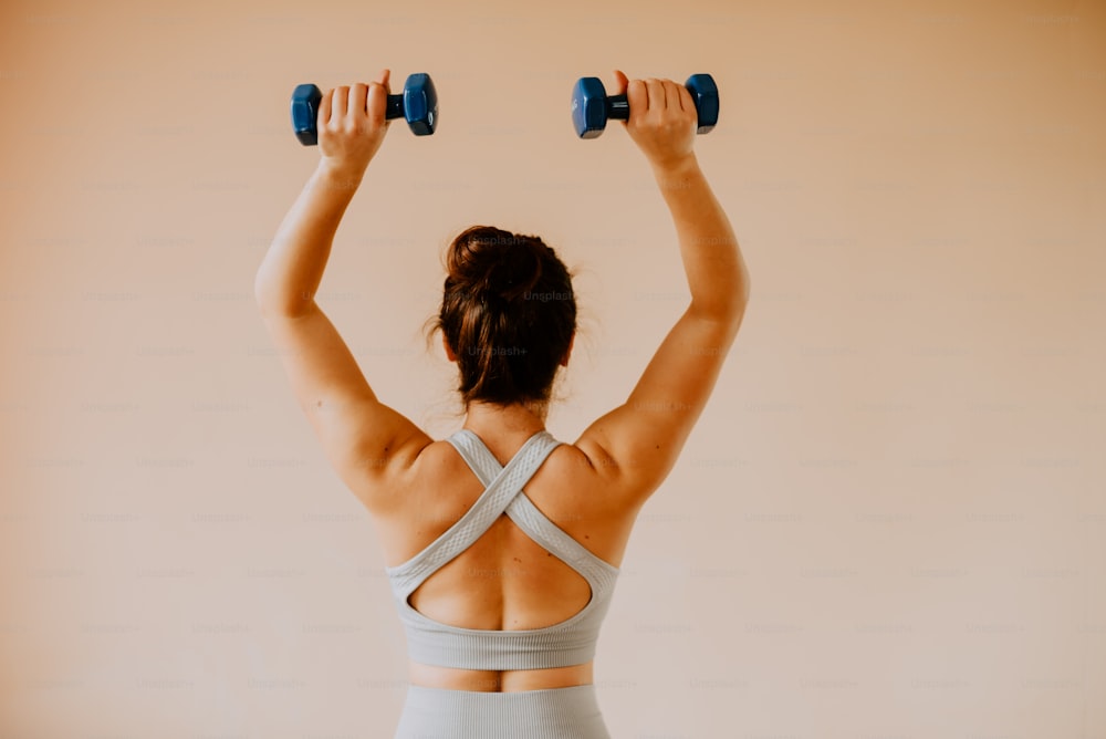 A woman doing a back squat with two dumbbells photo – Working out Image on  Unsplash