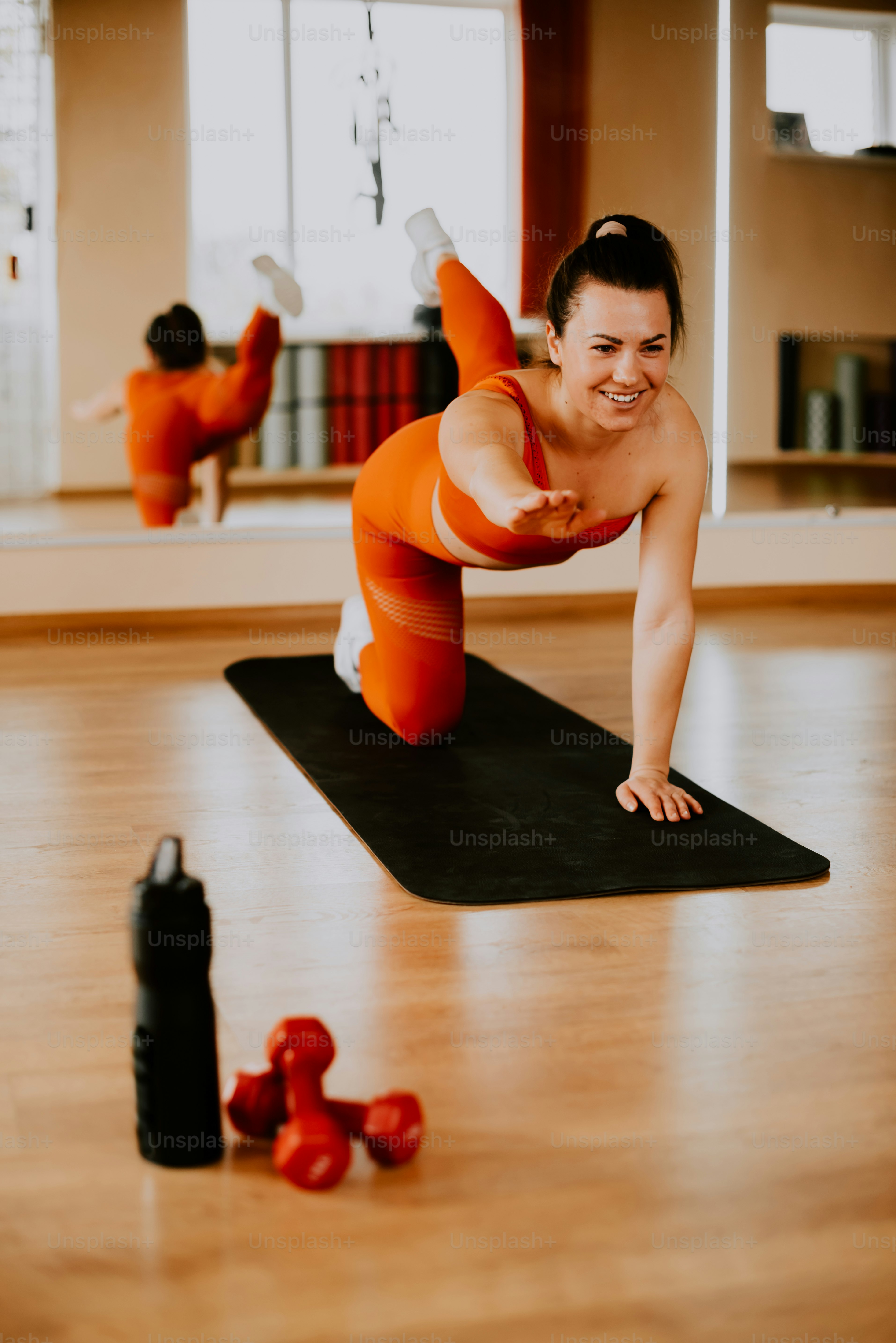 Una mujer está haciendo flexiones en una esterilla de yoga