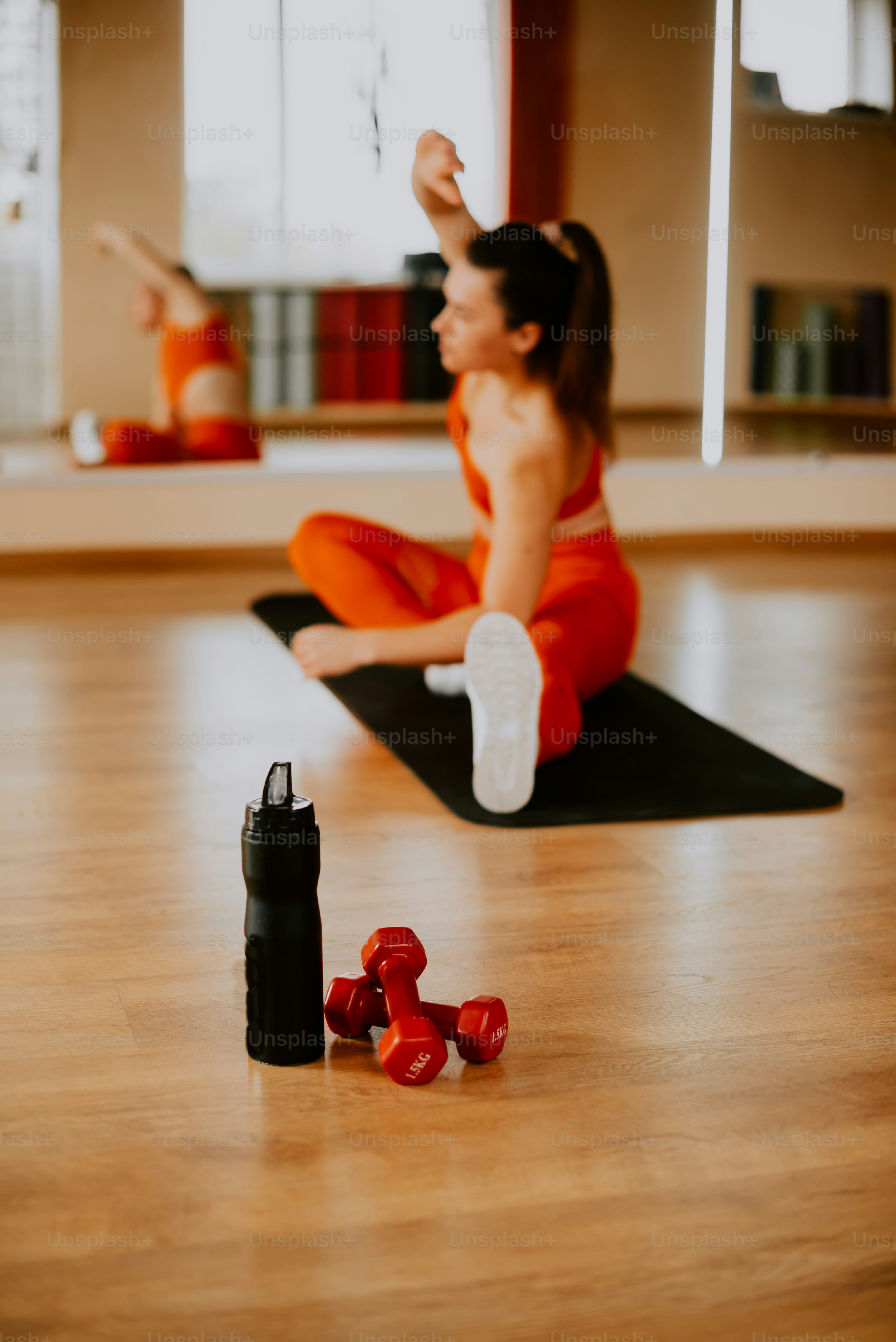 a woman in an orange outfit is doing yoga