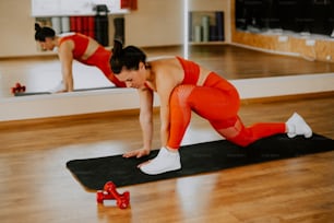 a woman is doing a plank exercise on a mat
