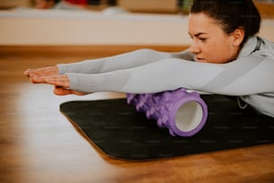 a woman laying on her stomach on a yoga mat