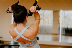 a woman holding a pair of black dumbbells