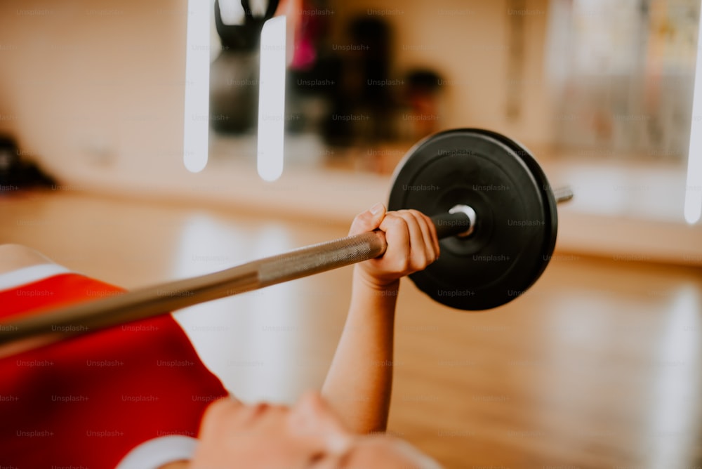 a young boy lifting a barbell in a gym