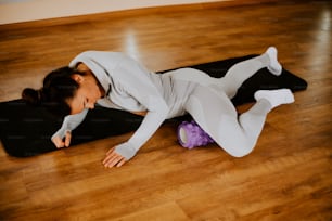 a woman laying on top of a yoga mat