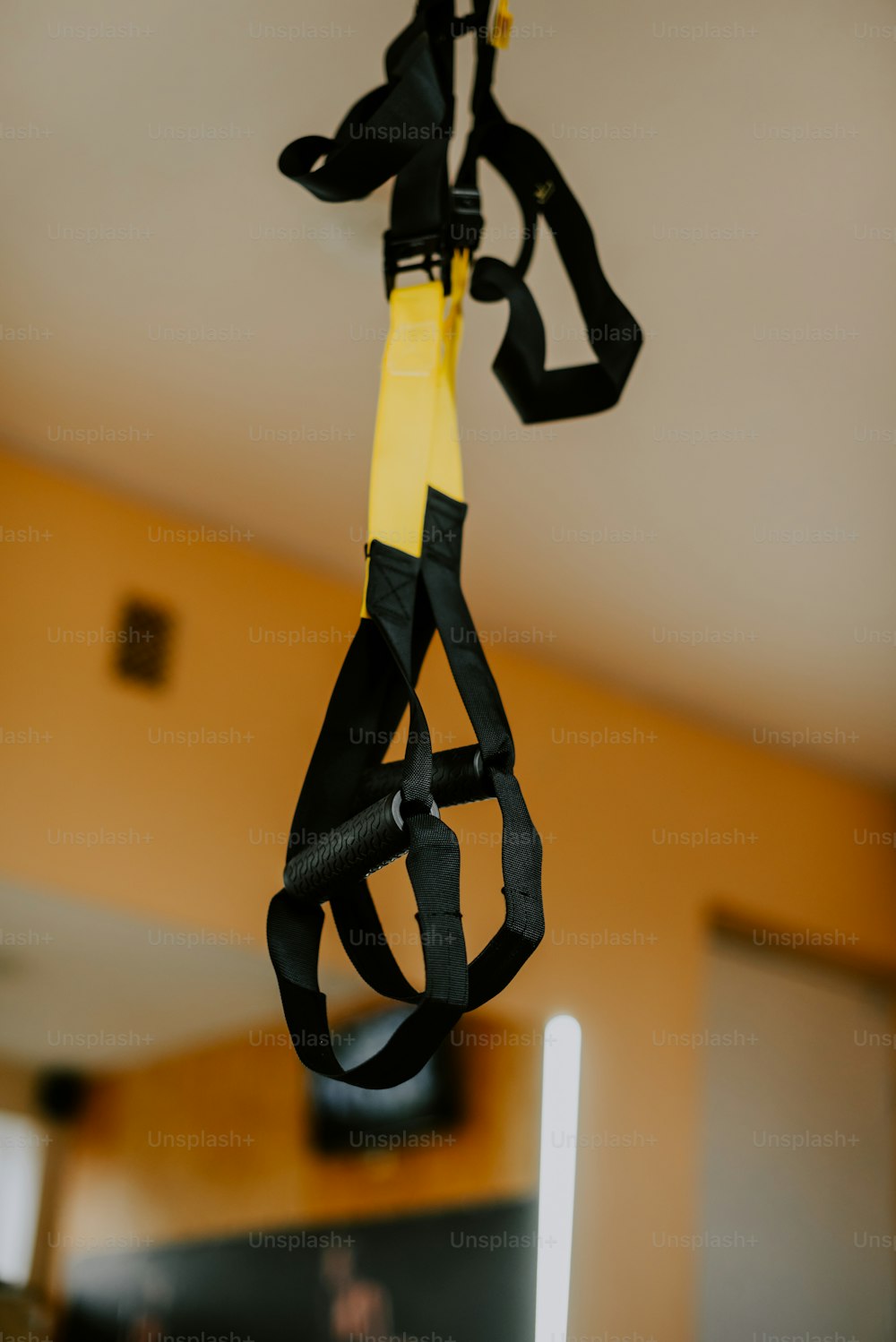 a black and yellow kite hanging from a ceiling