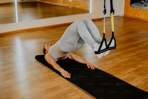 a woman doing a back stretch on a yoga mat