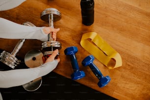 a person holding a dumbble bar next to a pair of dumbbells