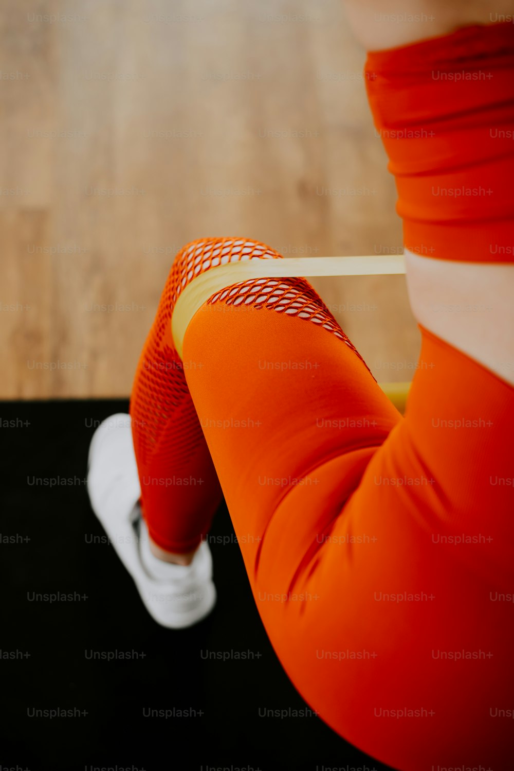 a person sitting on a skateboard on a wooden floor