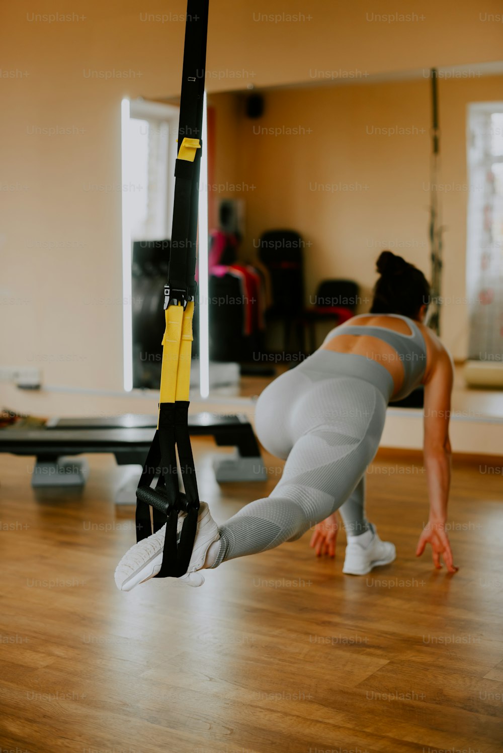 Una mujer haciendo una flexión en un poste