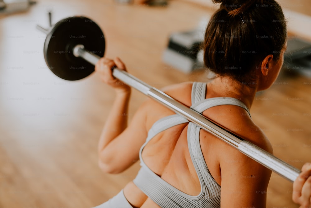 a woman lifting a barbell in a gym