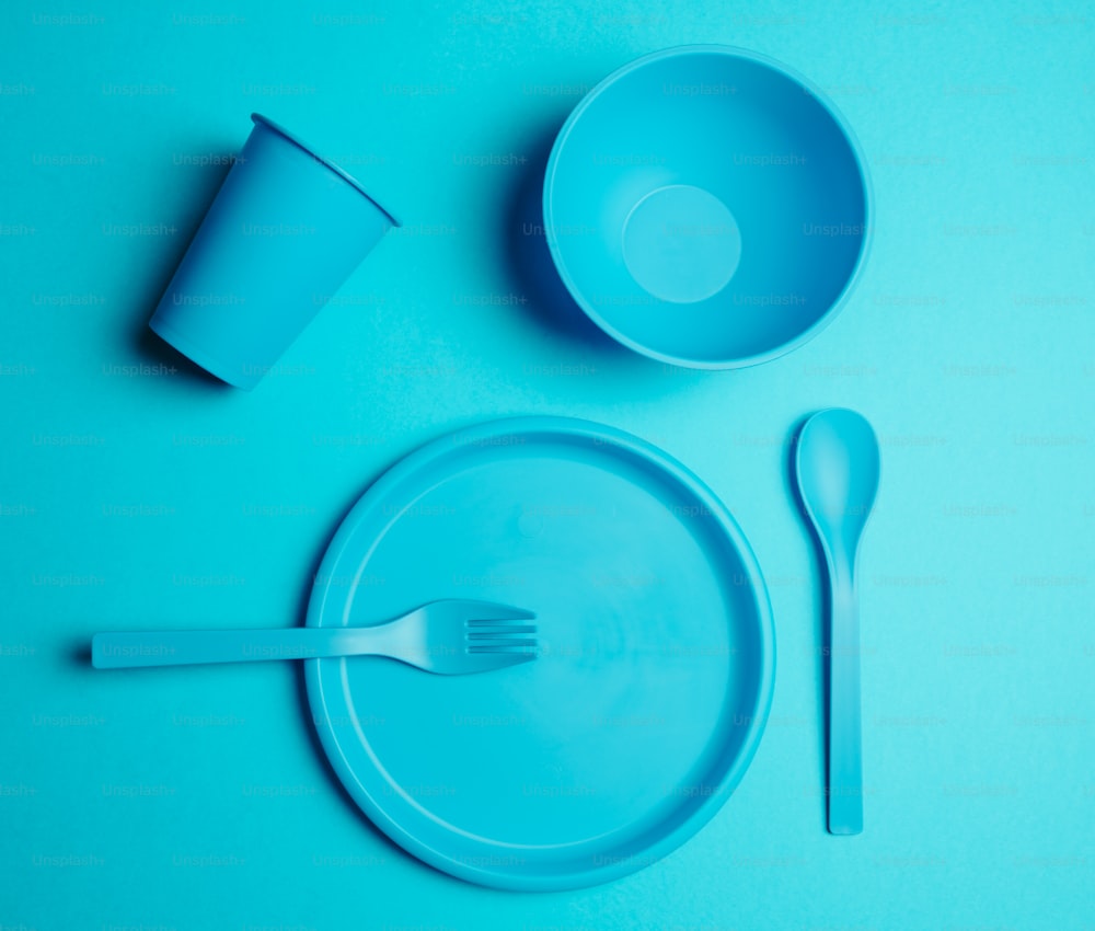 a blue plastic table set with a fork and a cup