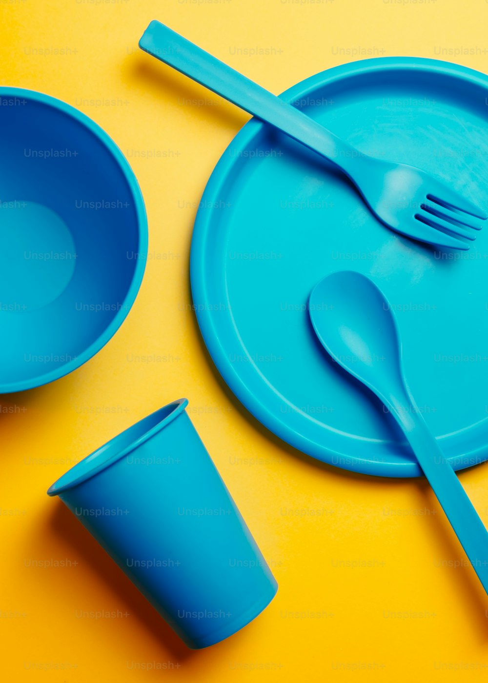 a blue plastic plate with a fork and a cup