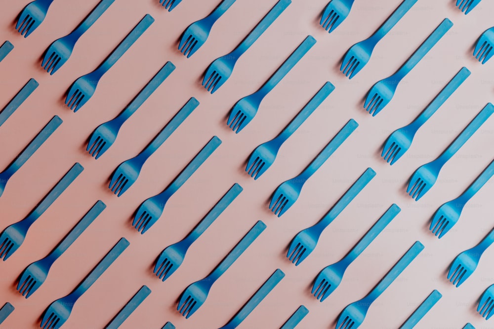ein Muster aus blauen Zahnbürsten auf rosafarbenem Hintergrund