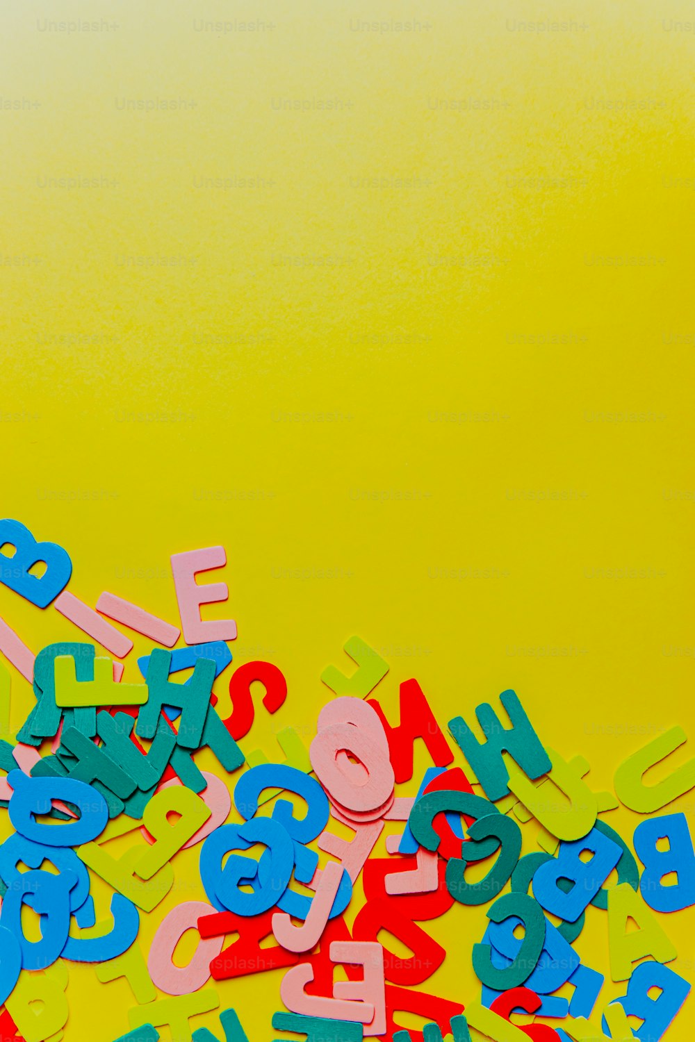 a pile of colorful letters and numbers on a yellow background