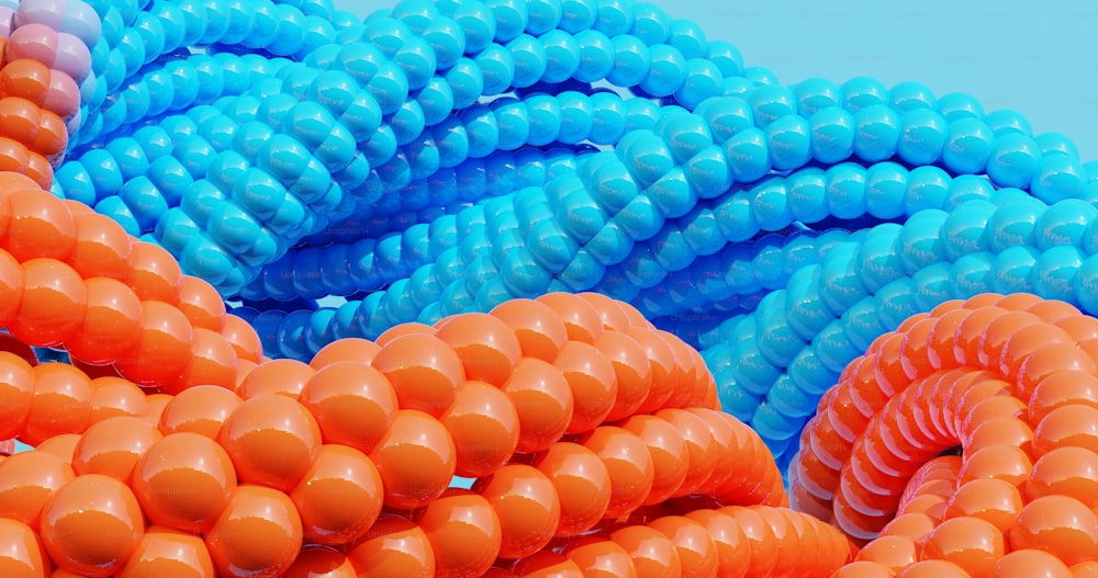 a bunch of orange and blue balloons are stacked on top of each other