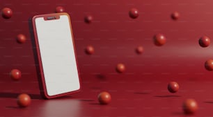 a red and white cell phone sitting on top of a table