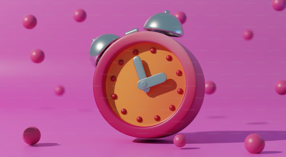 a pink alarm clock surrounded by pink balls