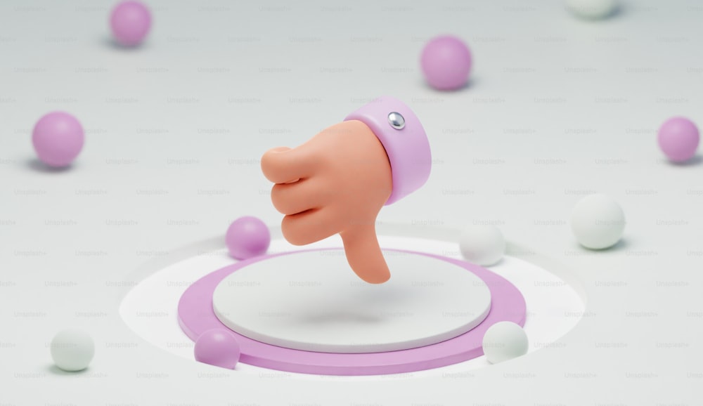 um objeto rosa com um polegar para cima em uma superfície branca