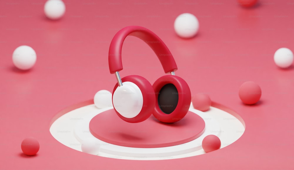 분홍색 표면 위에 앉아 있는 한 쌍의 헤드폰