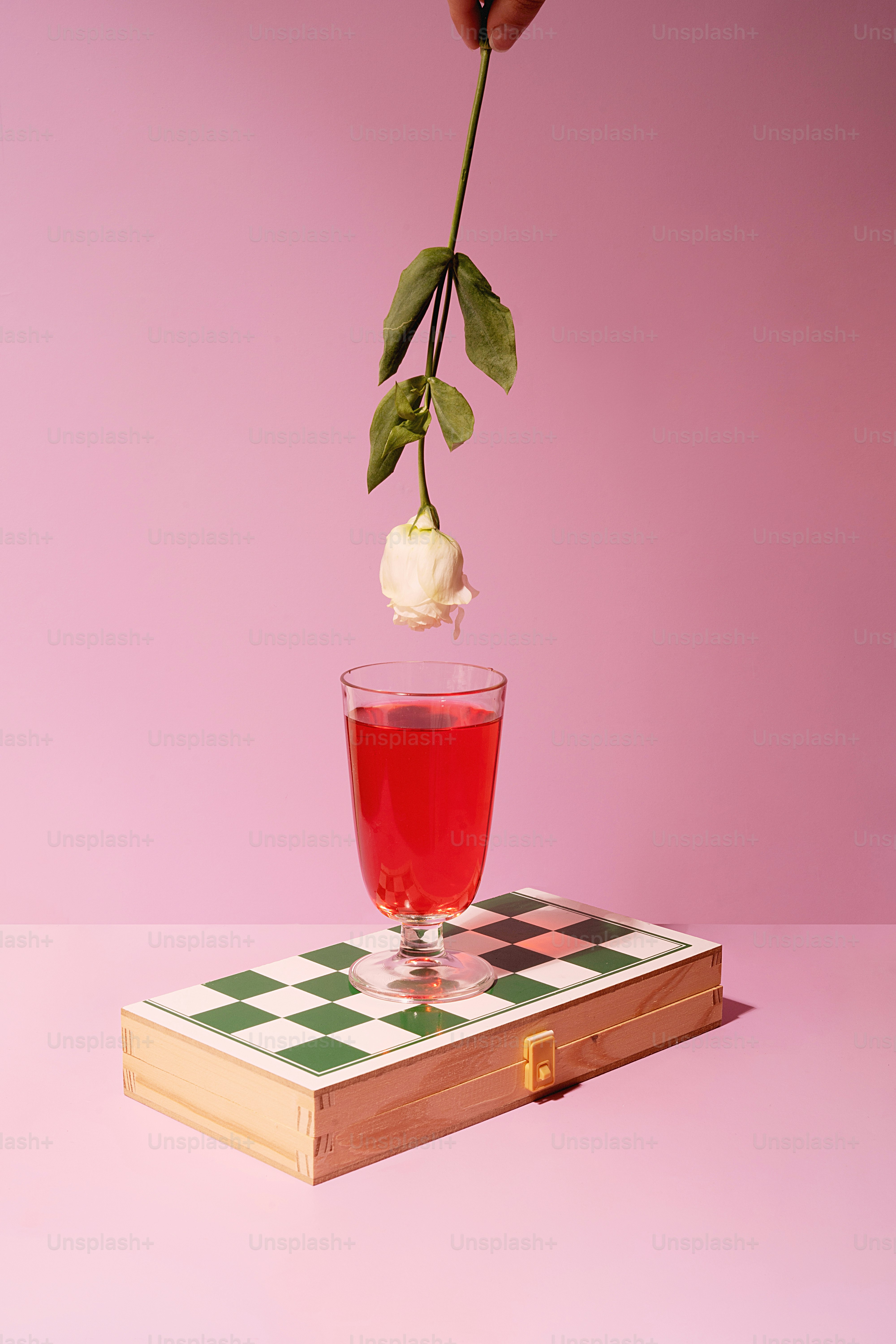 une personne tenant une fleur dans un verre de thé