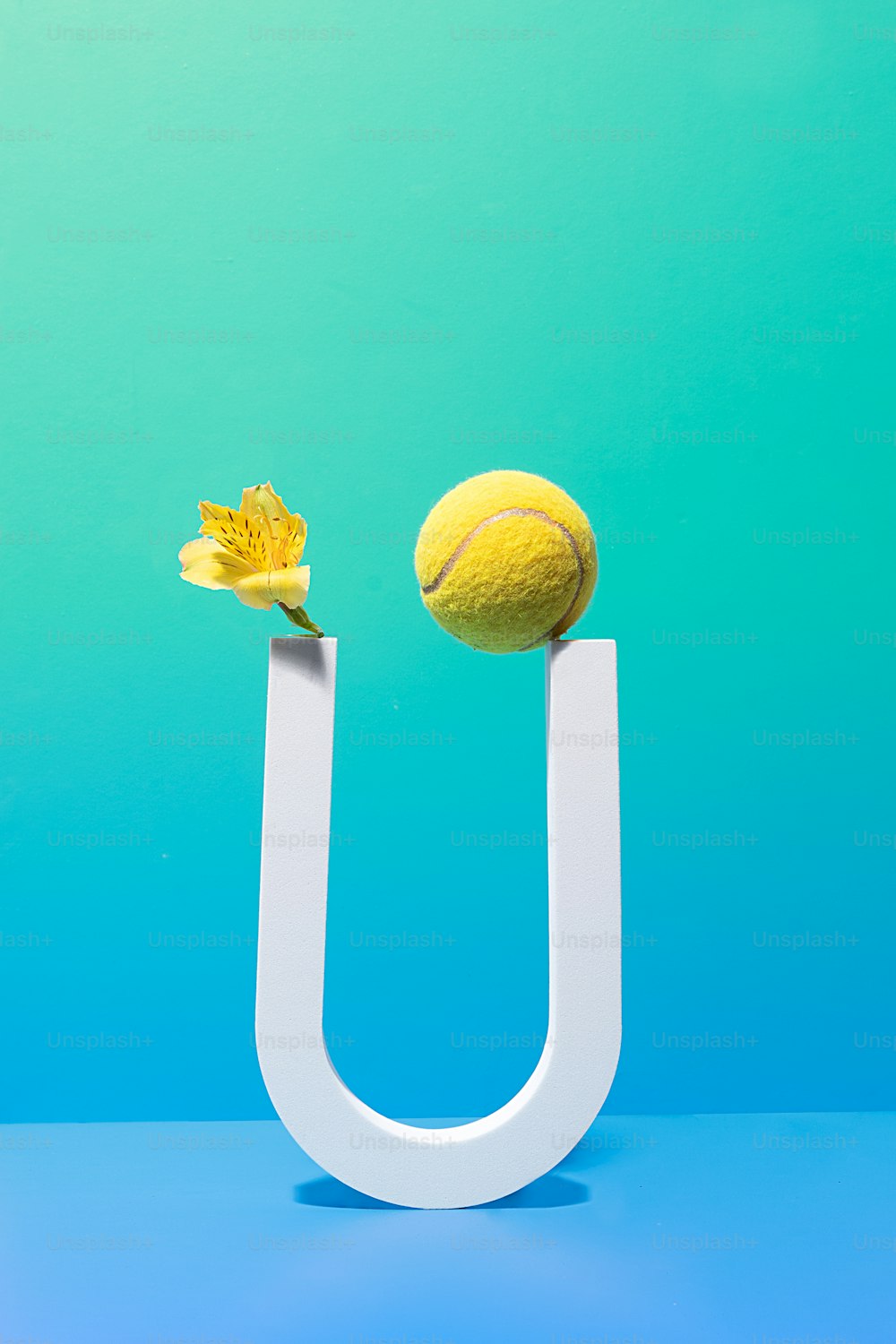 a tennis ball and a flower on a letter u