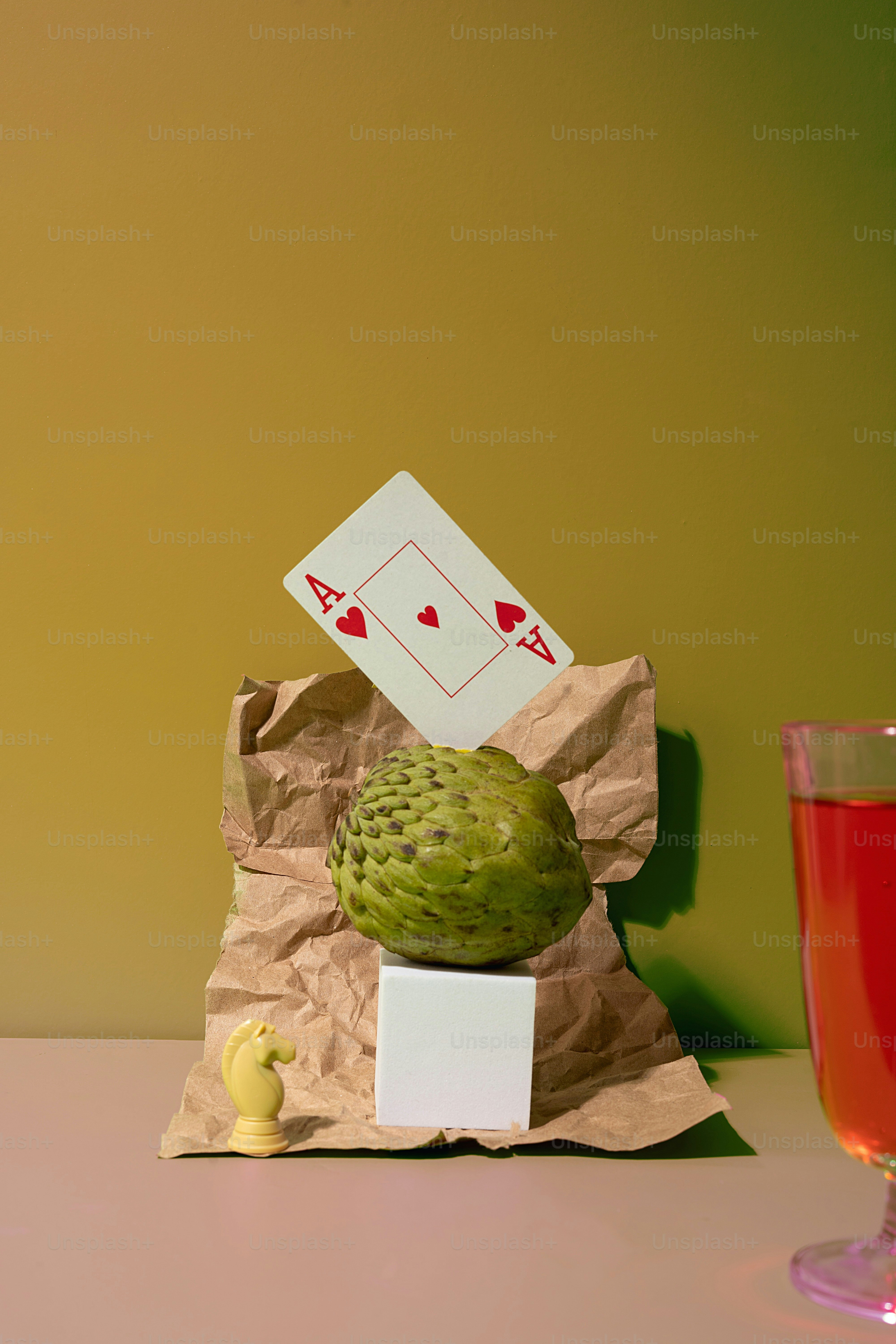 un cactus vert assis sur un morceau de papier à côté d’un verre de