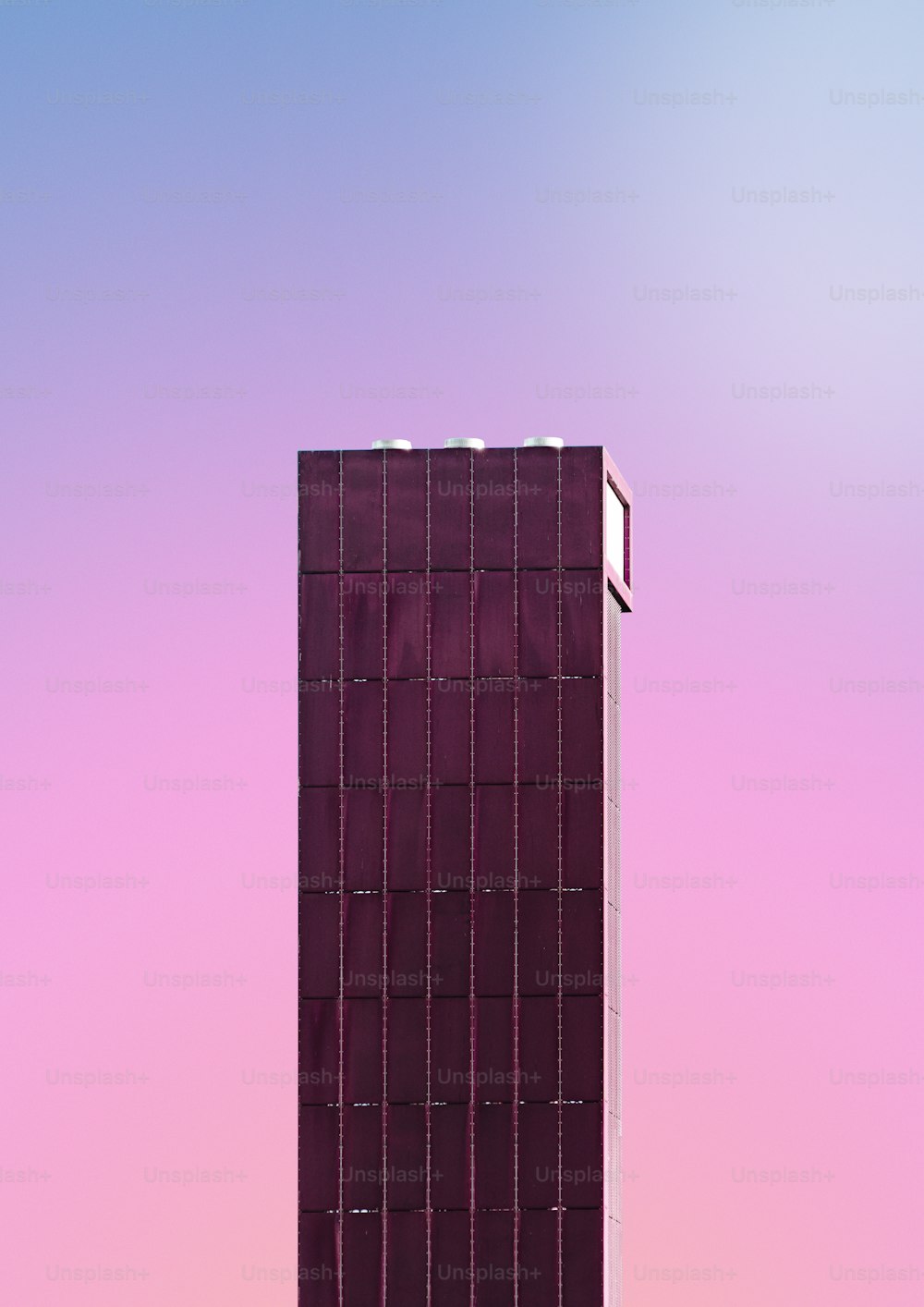 a tall purple building with a sky background