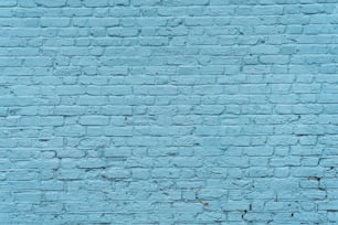 a blue brick wall with a clock on it