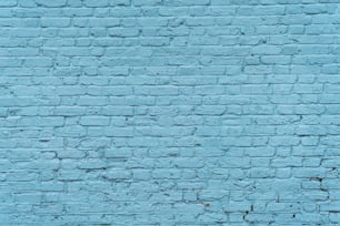 eine blaue Backsteinmauer mit einer Uhr darauf